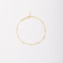 Gold-tone chain bracelet with eight round bezel-set stones, shown laid flat on a light background.