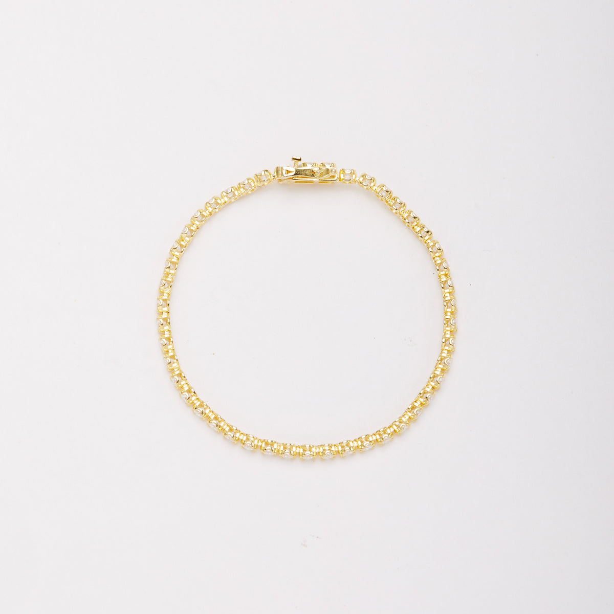 Overhead view of a gold-tone bracelet in a closed circle, showing the sides of the stone settings and clasp. Main image