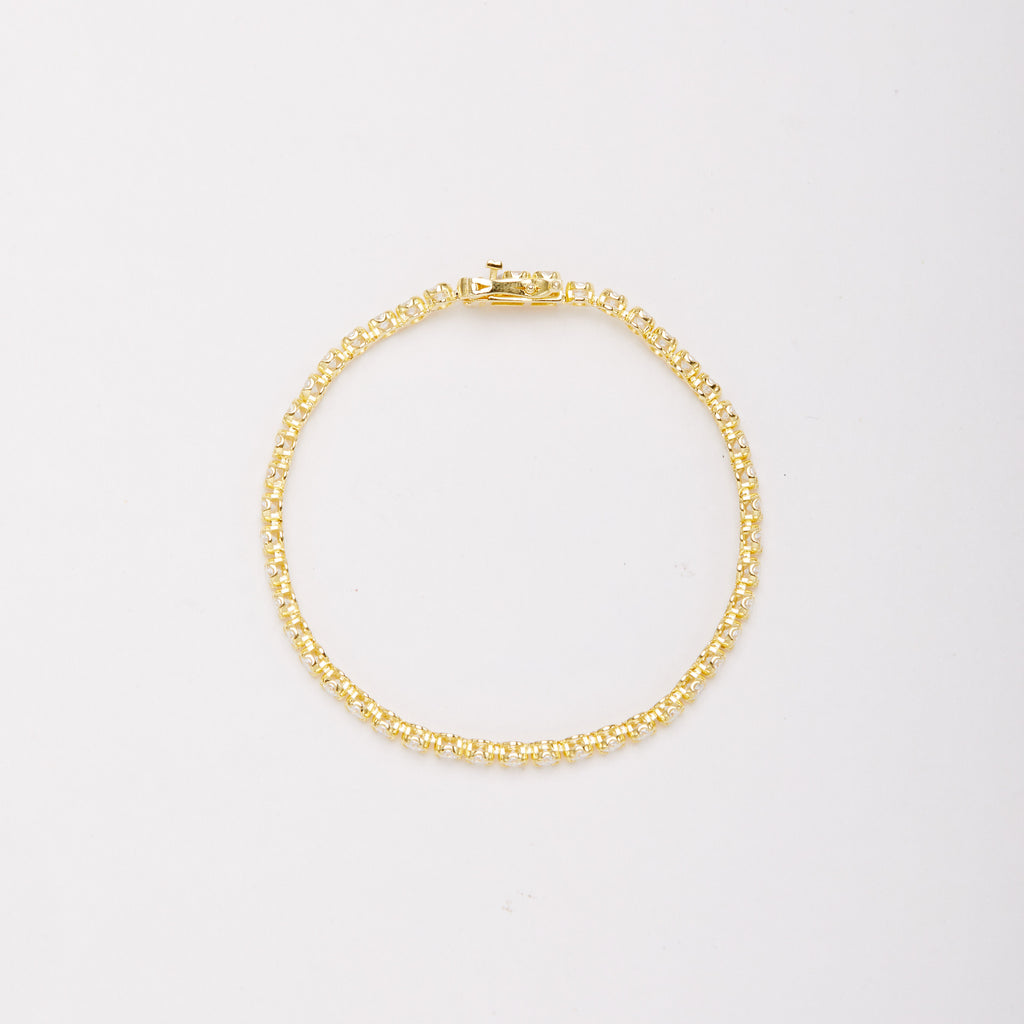 Overhead view of a gold-tone bracelet in a closed circle, showing the sides of the stone settings and clasp.