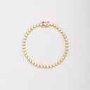 Gold-tone bracelet with heart-shaped clear stones in bezel settings, laid flat in a closed loop with the clasp at the top.