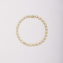Gold-tone bracelet with pear-shaped bezel-set stones, shown laid flat in a loop on a light background.