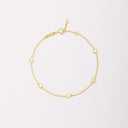 Gold-tone chain bracelet with five round bezel-set stones, shown laid flat on a light background.