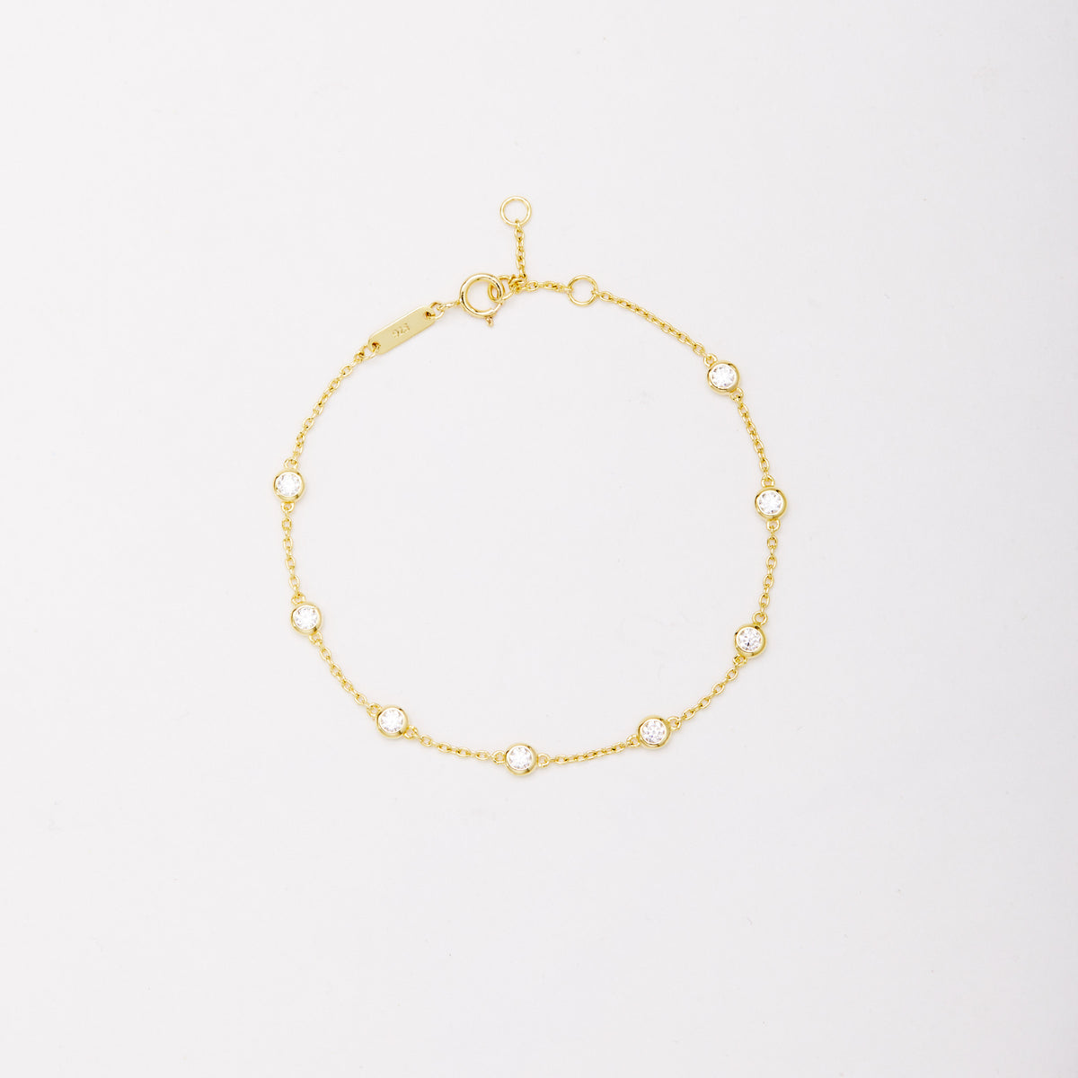 Gold-tone chain bracelet with eight round bezel-set stones, shown laid flat on a light background. Main image